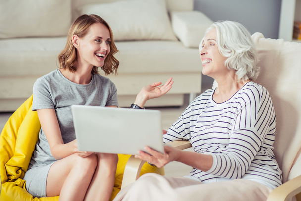 Cheerful woman and her grandmother using laptop - Photo, Image