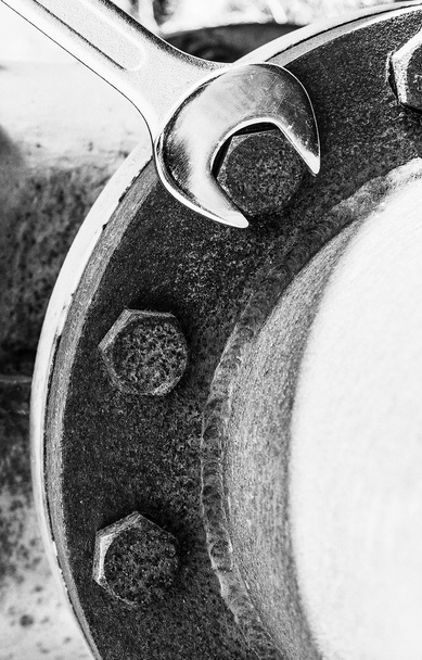Llave nueva brillante en un tornillo oxidado
 - Foto, imagen