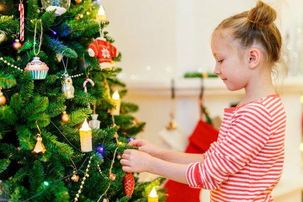 Little girl decorating Christmas tree - Foto, Imagem