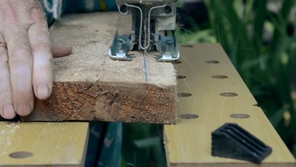 Man gezaagd een houten plank met een elektrische puzzel. - Video