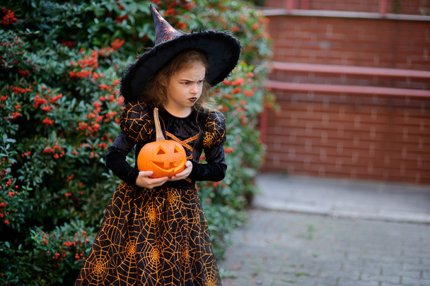All Saints' Day. Cute little girl portrays the wicked witch. - Fotografie, Obrázek
