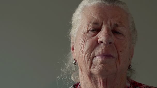 Großmutter in Großaufnahme, die in die Kamera blickt - Filmmaterial, Video