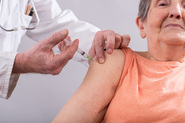 Senior woman getting an injection - Foto, Imagen