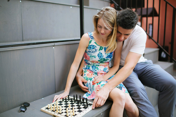 Young beautiful couple playing chess outdoors in city - Photo, Image