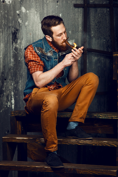 Genç adam merdivenlerde otururken bir puro Sigara - Fotoğraf, Görsel