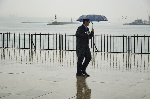 Istanbul steamboat pier people walking in the rain. - Φωτογραφία, εικόνα
