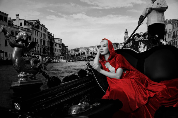 Beautifiul woman in red cloak riding on gandola - Photo, Image