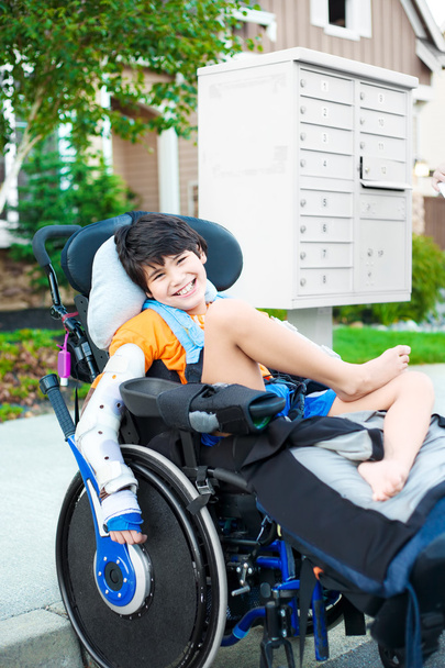 Handsome biracial disabled boy in wheelchair, smiling outdoor, r - Fotografie, Obrázek