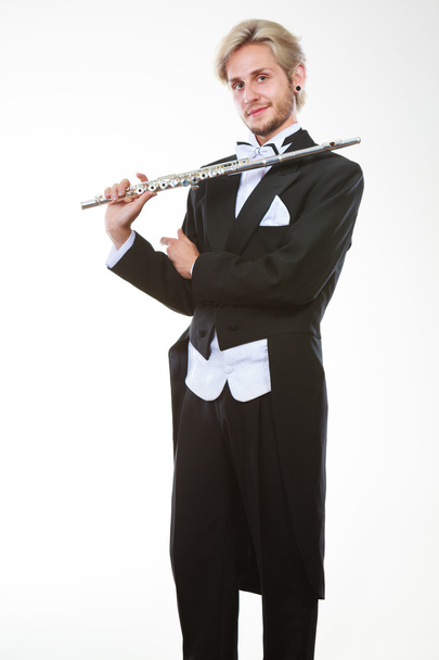 Mannelijke fluitist Rokkostuum dragen houdt fluit - Foto, afbeelding