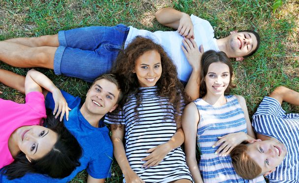 Happy friends lying on grass - Photo, Image