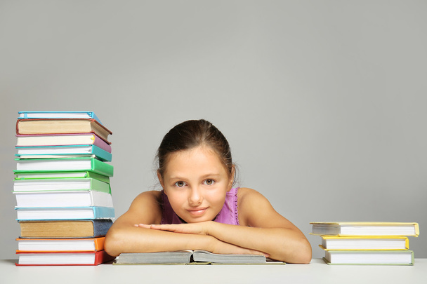 Cute girl with books on grey background - 写真・画像
