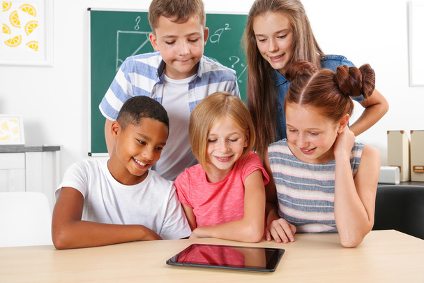 Schoolchildren with tablet computer in classroom - Valokuva, kuva