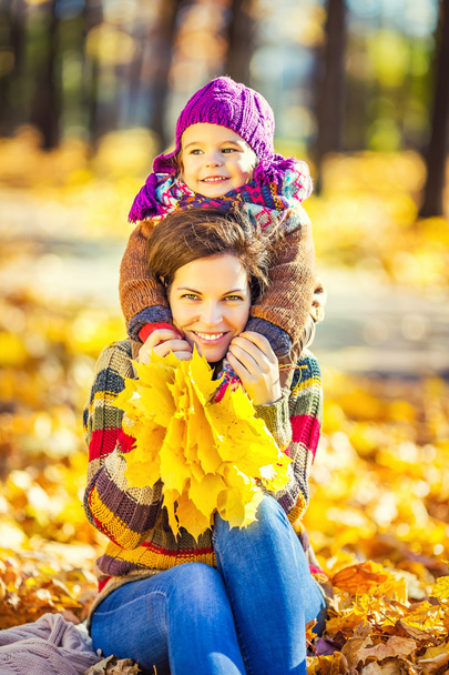 Mother and daughter playing in autumn park - Foto, immagini