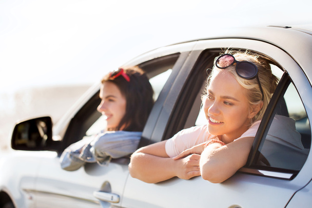 happy teenage girls or women in car at seaside - Φωτογραφία, εικόνα