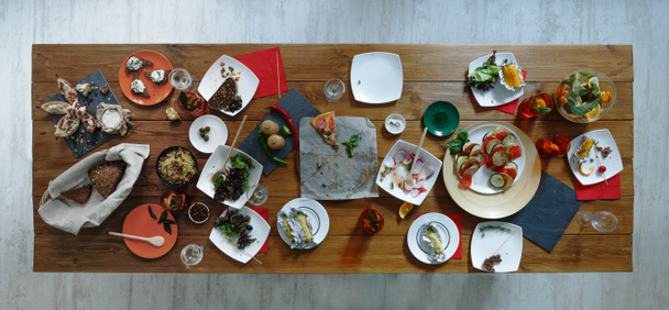 Po imprezie. Zmarnowane jedzenie na drewniany serwowany świąteczny stół - Zdjęcie, obraz