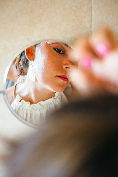 Mujer haciendo maquillaje en el espejo
 - Foto, imagen