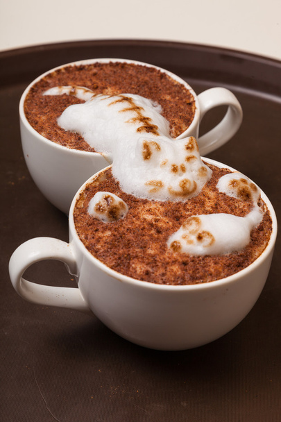 Кофе с пеной в виде кошки и мыши на коричневом столе
 - Фото, изображение