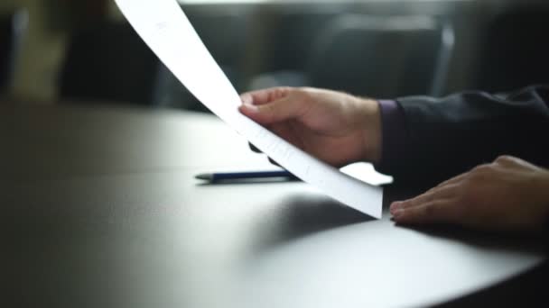 mężczyzna podpisujący kontrakt lub formularz subskrypcji z długopisem na drewnianym biurku w stylu rustykalnym - Materiał filmowy, wideo