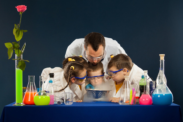 glückliche Kinder mit Wissenschaftlern, die naturwissenschaftliche Experimente im Labor durchführen - Foto, Bild