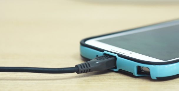 зарядка смартфона на деревянном столе
 - Фото, изображение