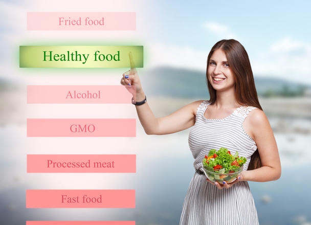 未来的な画面上の健康食品を選ぶ女性の笑みを浮かべて - 写真・画像