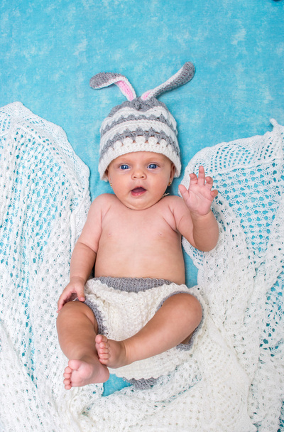 piccolo bambino carino nel coniglietto tappo su uno sfondo blu
 - Foto, immagini