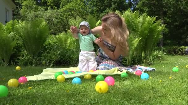 Vrolijke moeder spelen met baby op weide. 4k - Video