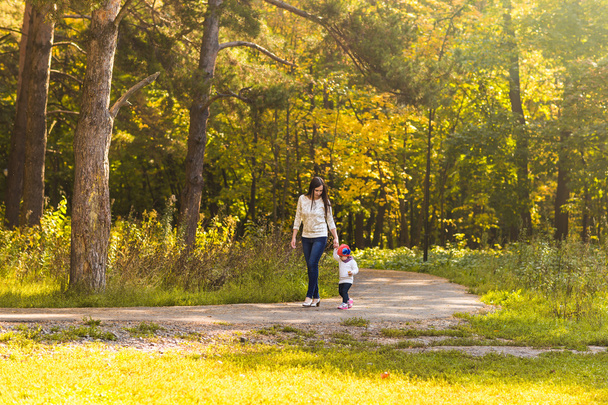 junge Mutter mit ihrem kleinen Mädchen im Herbstpark - Foto, Bild