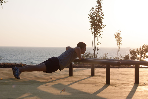 Young male doing push ups - Фото, изображение