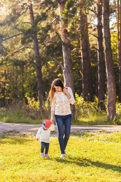 Młoda matka z jej małą córeczkę w parku jesień - Zdjęcie, obraz