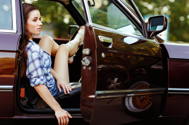 Girl sitting in open car, photo toned - Fotografie, Obrázek
