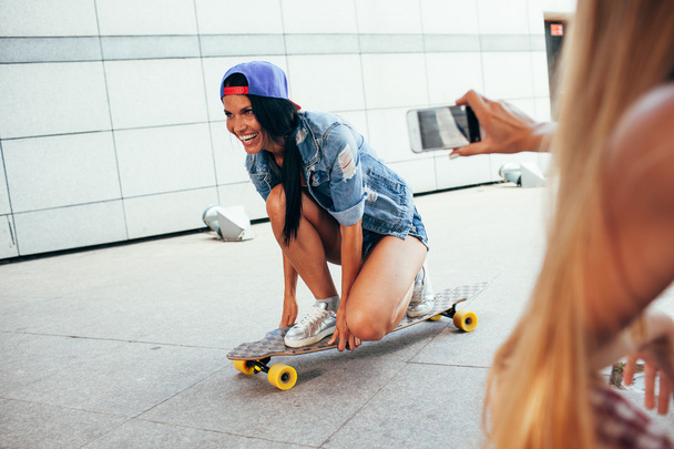 one woman shooting other on longboard - 写真・画像