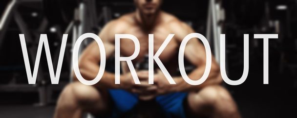 The word WORKOUT in the blurry background bodybuilder in the gym. - Φωτογραφία, εικόνα