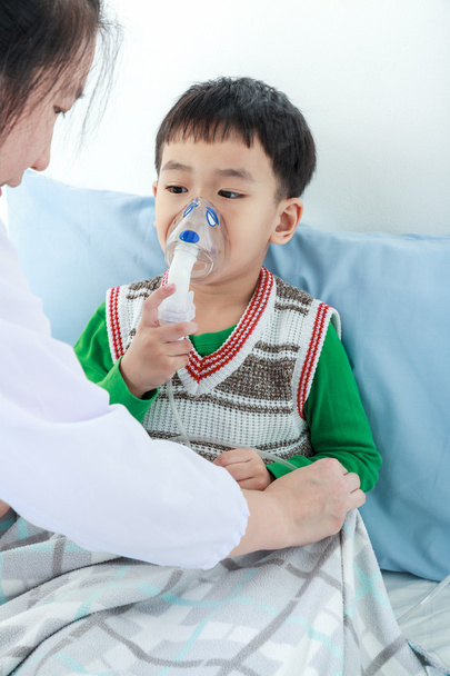 Азіатський хлопчик, маючи респіраторні захворювання, допомогла з інгалятор професійного здоров'я.  - Фото, зображення