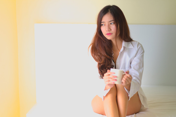Güzel esmer kadın içme ve sabah kahve yatak odasında  - Fotoğraf, Görsel