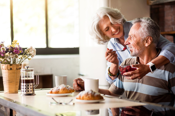 引退した男と女がキッチンで朝食を持っていること - 写真・画像
