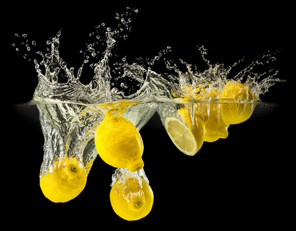 Group of fresh fruits falling in water with splash on black background - Photo, image
