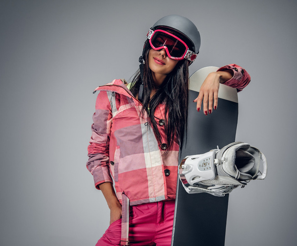 Жінка в рожевому лижному костюмі, що тримає сноуборд
 - Фото, зображення