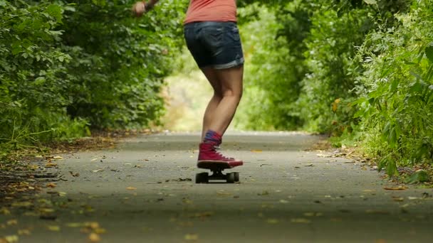 Νεανική κουλτούρα. Κορίτσι με skateboard άλμα στο πάρκο καλοκαίρι. Αργή κίνηση  - Πλάνα, βίντεο