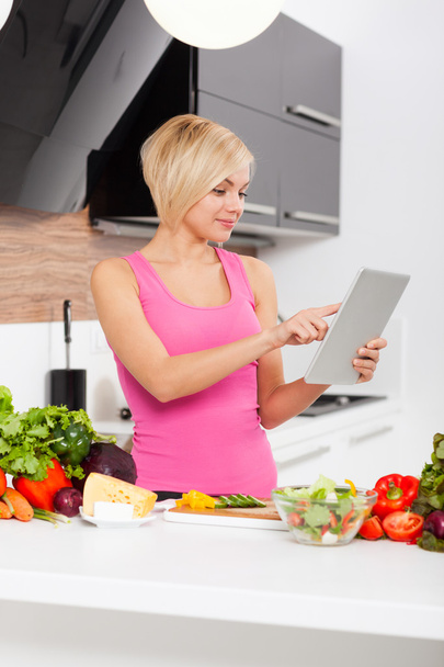 vrouw met behulp van een tablet-pc om te koken - Foto, afbeelding
