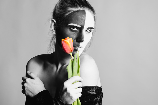 Woman portrait in black dress with greasepaint and tulip - Photo, Image