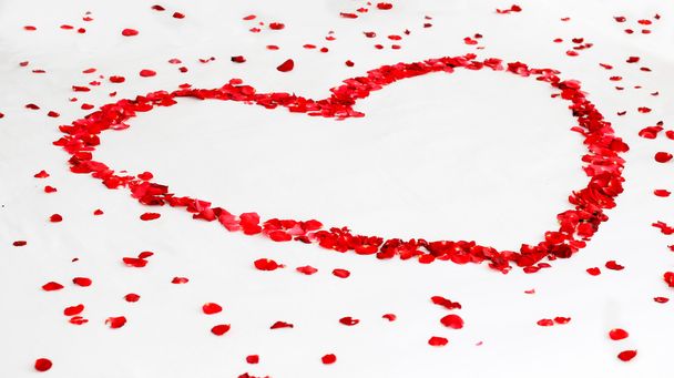 Románticas rosas rojas en forma de corazón entre pétalos sobre fondo blanco. Boda, día de San Valentín, amor, día de la madre, etc conceptos
. - Foto, imagen