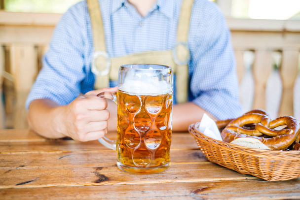 Man in bavarian clothes with beer and pretzels - Foto, Imagem