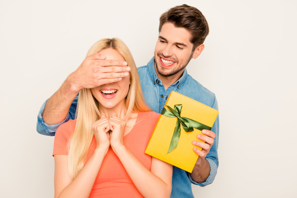 Surprise! Happy guy closing eyes of his girlfriend and holding y - Фото, зображення