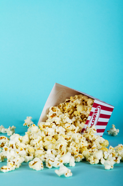 Popcorn emmer tegen een blauwe achtergrond - Foto, afbeelding