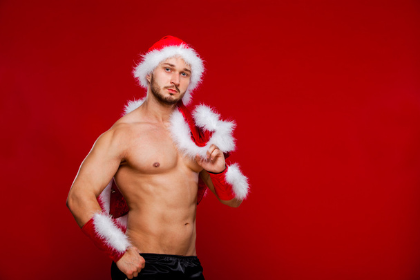 Sexy muscular man in santa uniform. Christmas New Year - Фото, изображение
