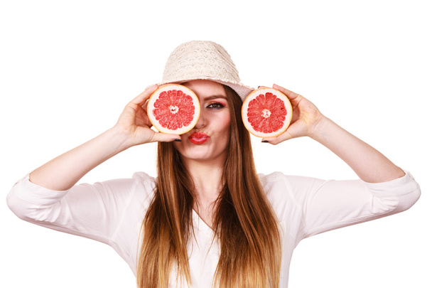 Girl covering eyes with two halfs of grapefruit citrus fruit - Foto, imagen