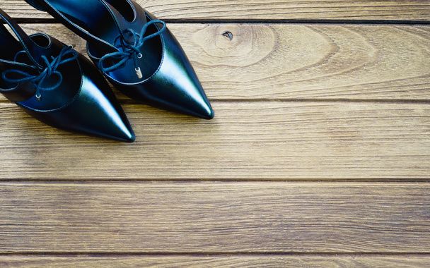 Black high heel shoes on wooden background - Fotó, kép