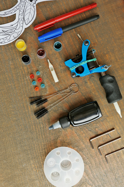 Tattoo machine and supplies on wooden background - Фото, изображение