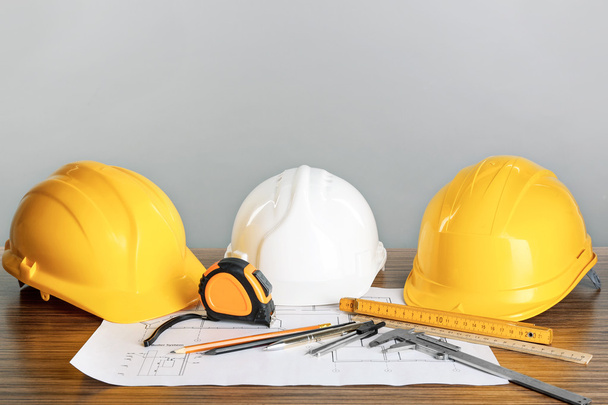 Construction blueprints with tools and helmets on light background - Foto, Imagen